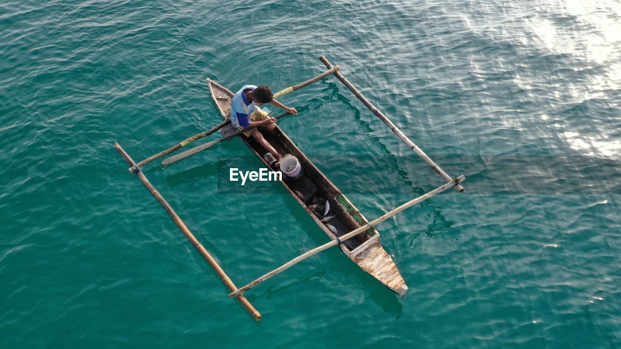 HIGH ANGLE VIEW OF WOMAN IN SEA