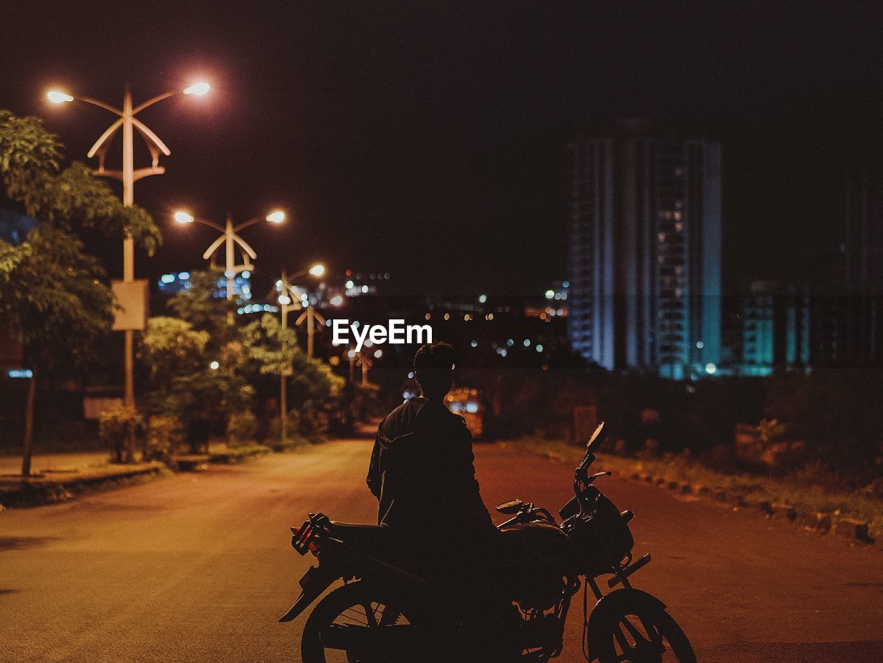 Man with illuminated cityscape at night