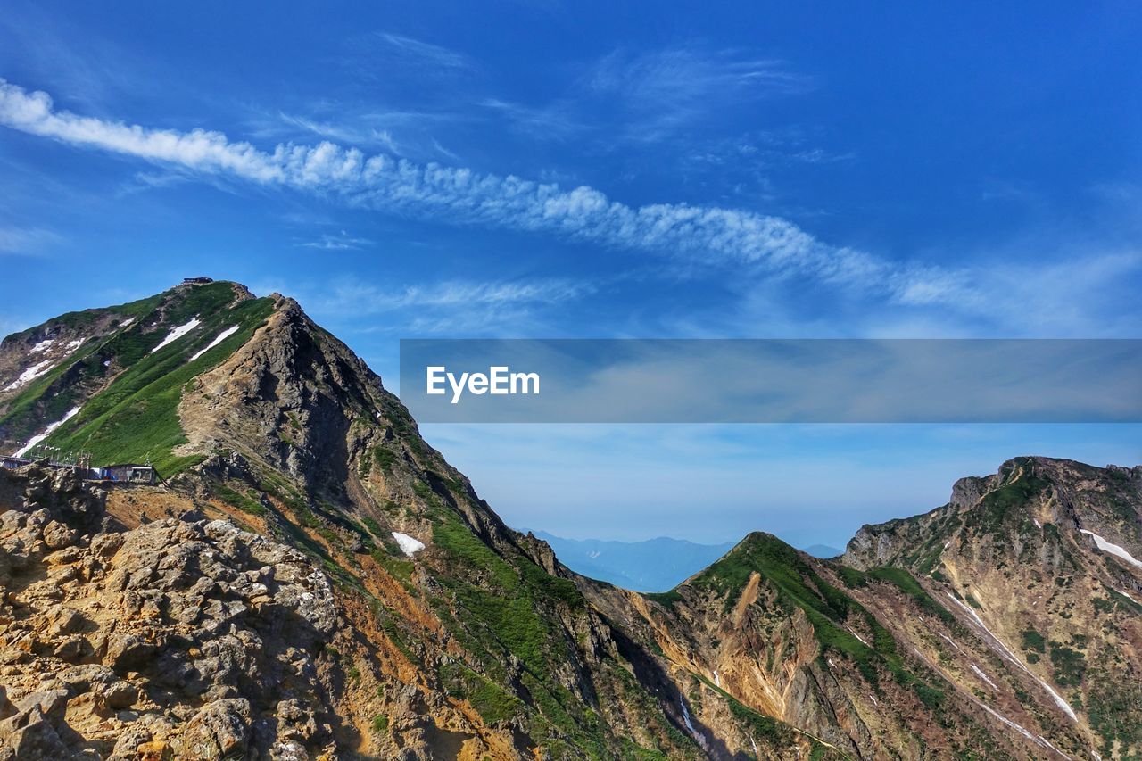 Scenic view of mountains against blue sky