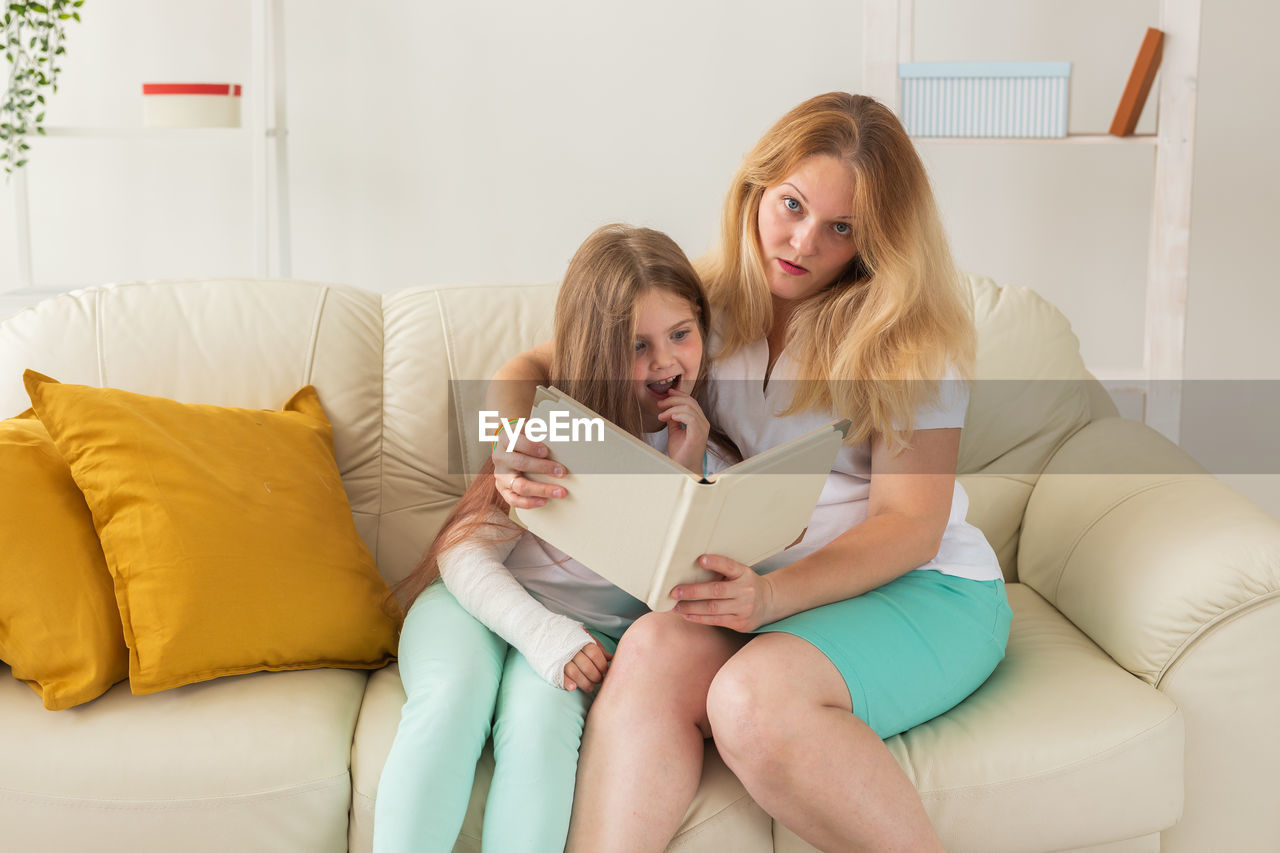 Young woman sitting on sofa at home