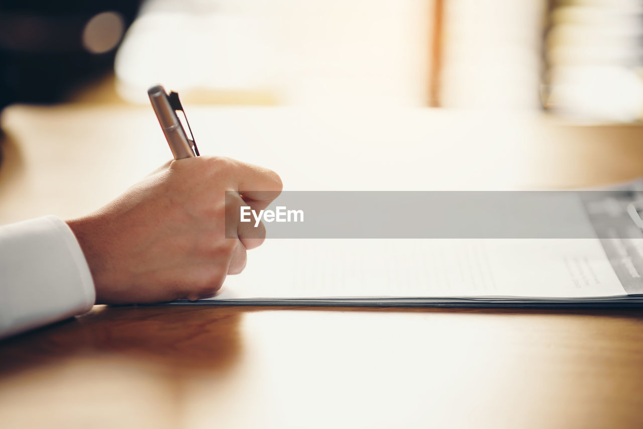 Hand of a businessman holding a pen is analyzing, business planner.