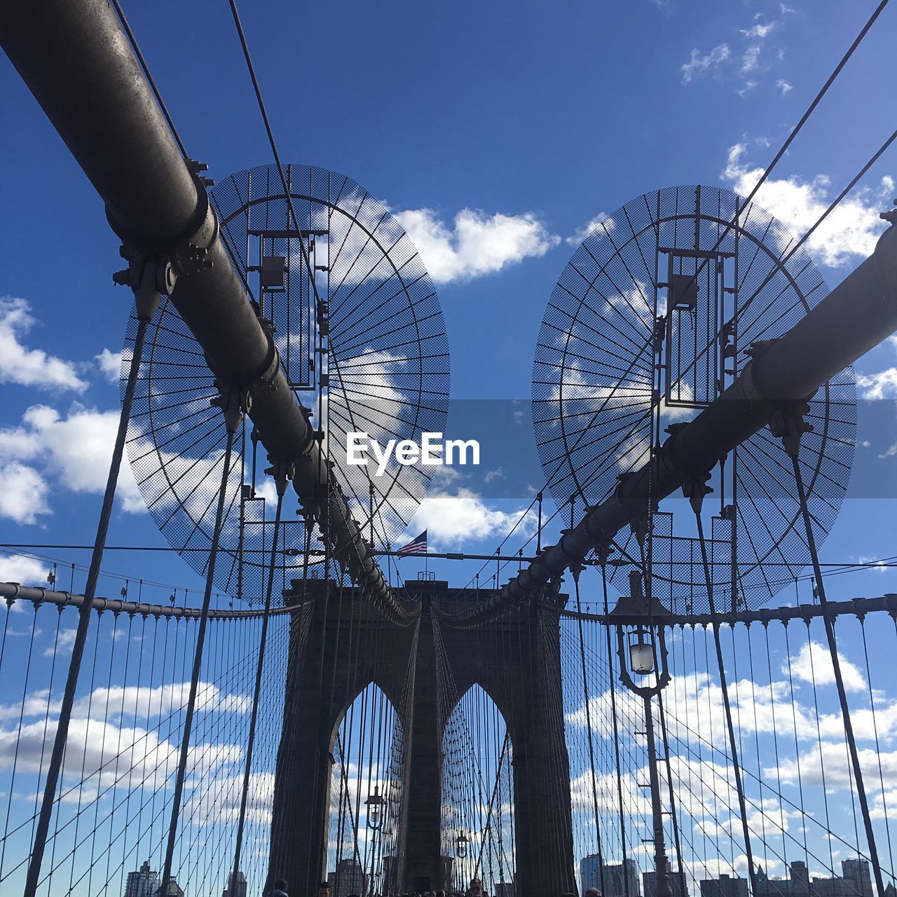 LOW ANGLE VIEW OF FERRIS WHEEL AGAINST CLOUDY SKY