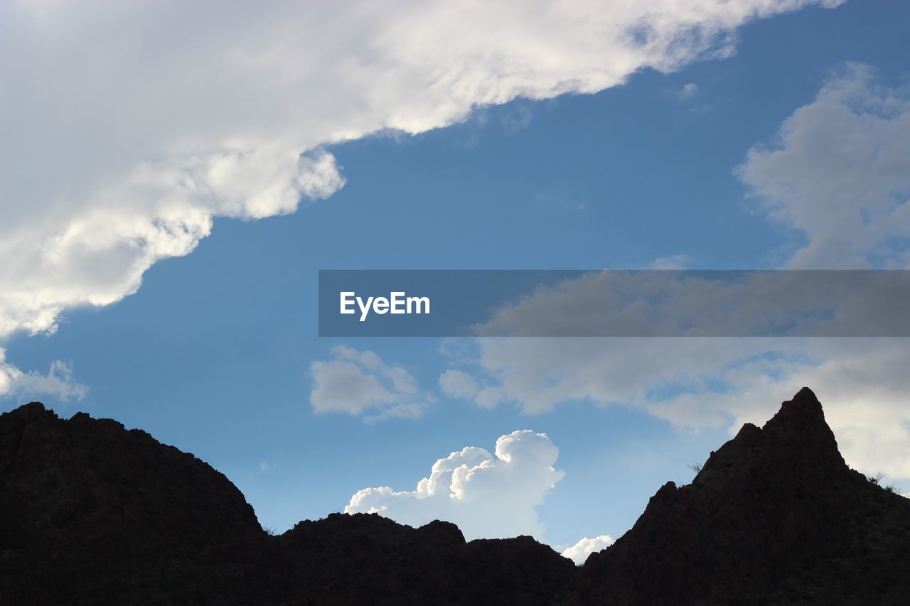 Low angle view of silhouette mountains against sky