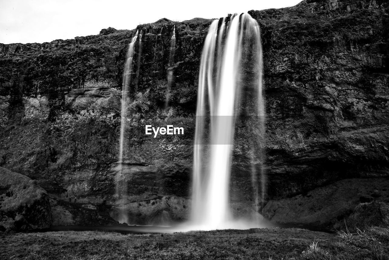 Low angle view of waterfall against the sky