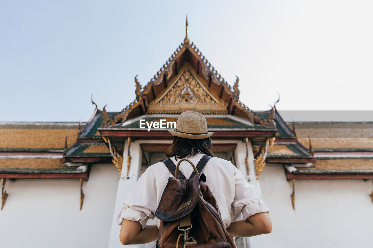 Back of tourist woman at wat suthat thepwararam ratchaworamahawihan temple, bangkok, thailand