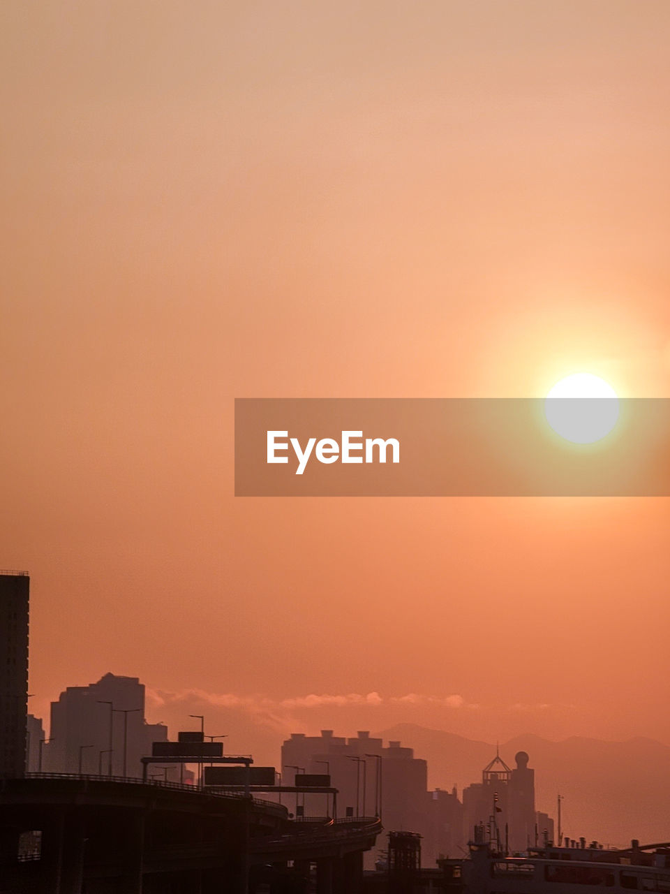 SILHOUETTE BUILDINGS AGAINST ORANGE SKY