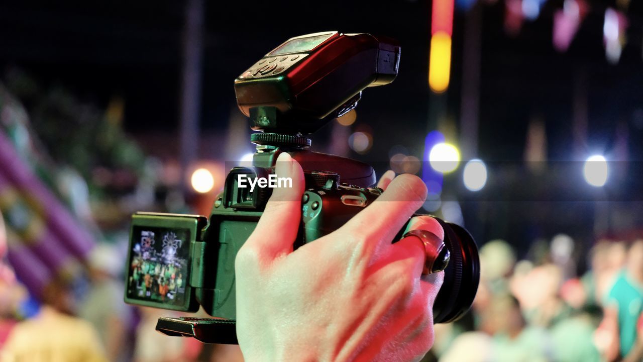 Cropped hand of person photographing at night