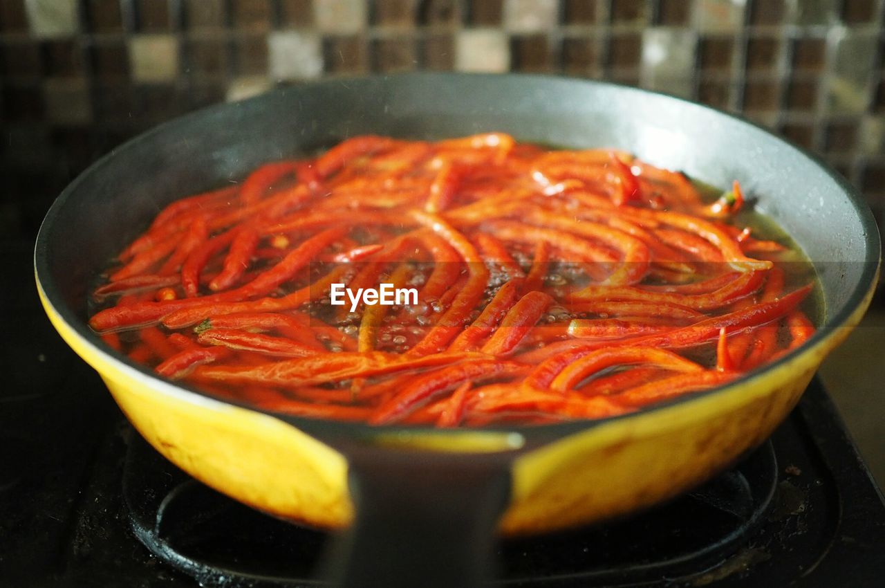 Close-up of red chilies in frying pan