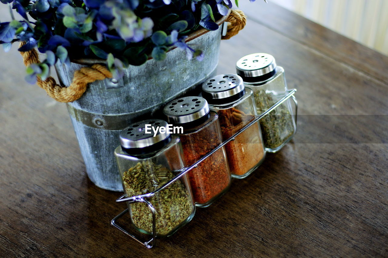 Condiment set with a vase of flowers on the table.