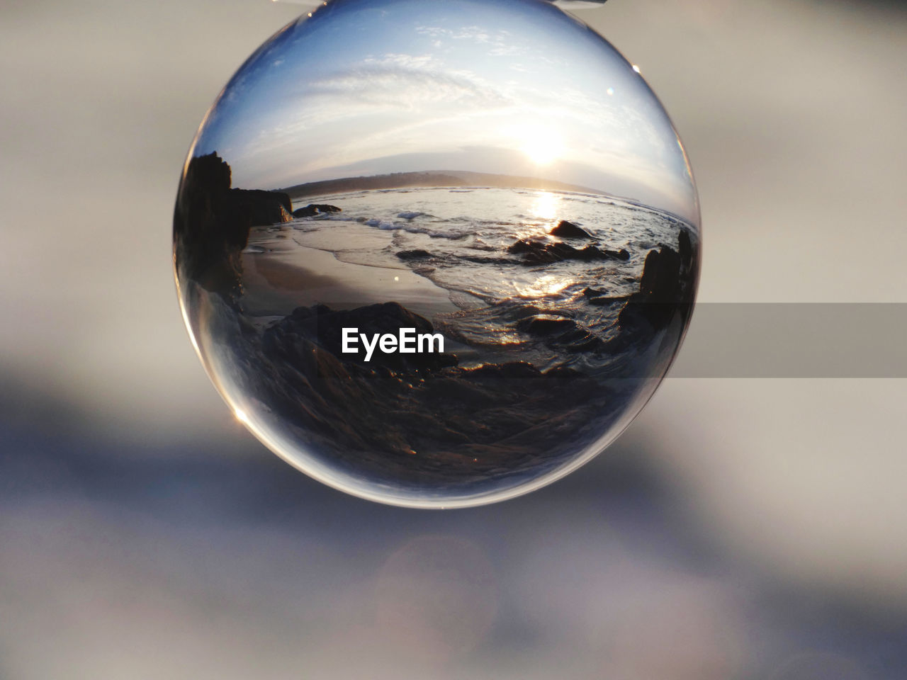 reflection, sphere, close-up, blue, nature, macro photography, planet earth, globe - man made object, space, glass, sky, planet, water, earth, single object, no people, light, crystal ball, outdoors, transparent, shape, geometric shape, environment, cloud, circle, focus on foreground, shiny, ball, sunlight, sunset