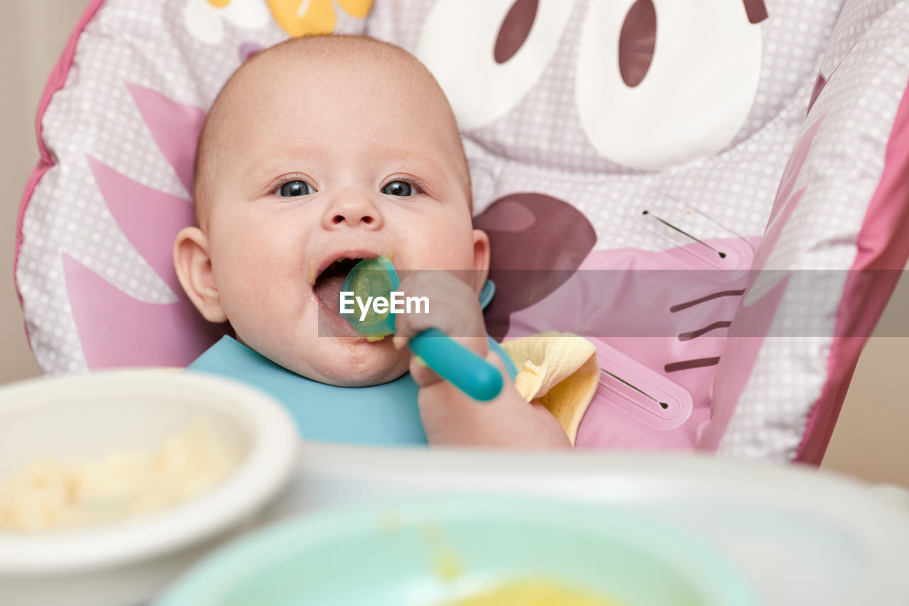 high angle view of cute baby girl eating food