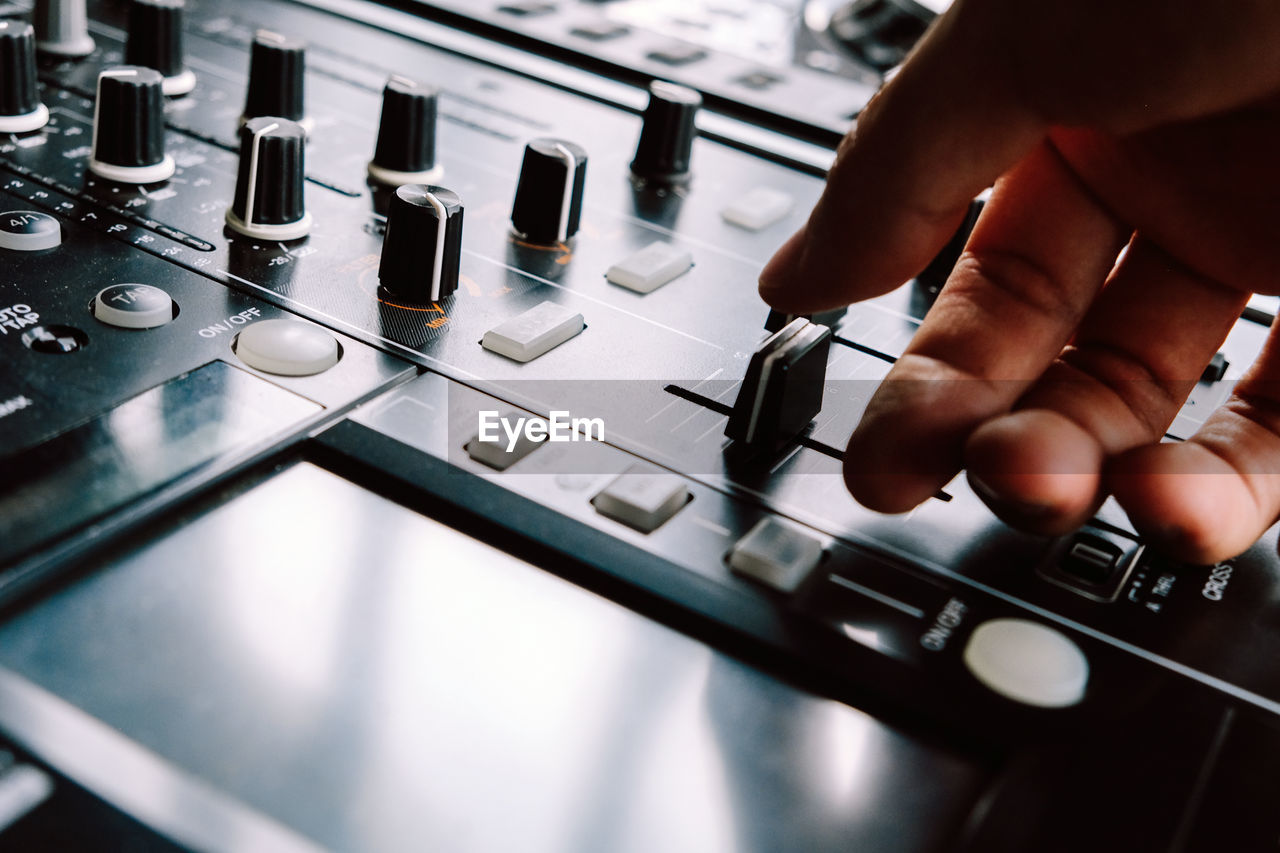 Close-up of cropped hand on control panel of turntable