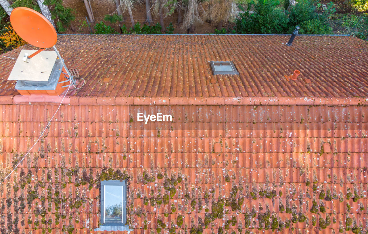 Inspection of the red tiled roof of a single-family house, inspection of the condition of the tiles 