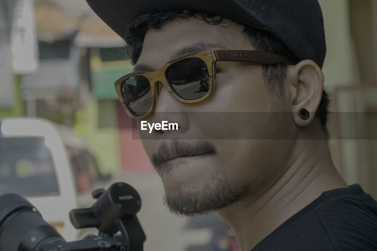 CLOSE-UP PORTRAIT OF MAN WEARING SUNGLASSES