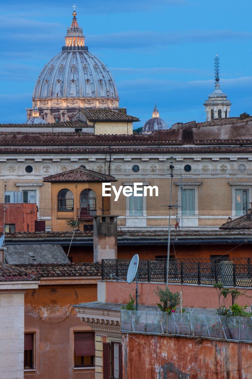 St peter basilica against sky in city at dusk