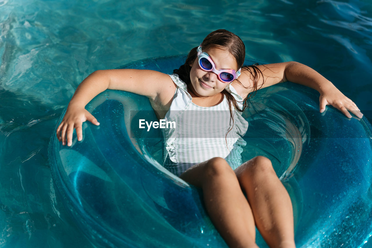  girl swimming on a floaty in the pool