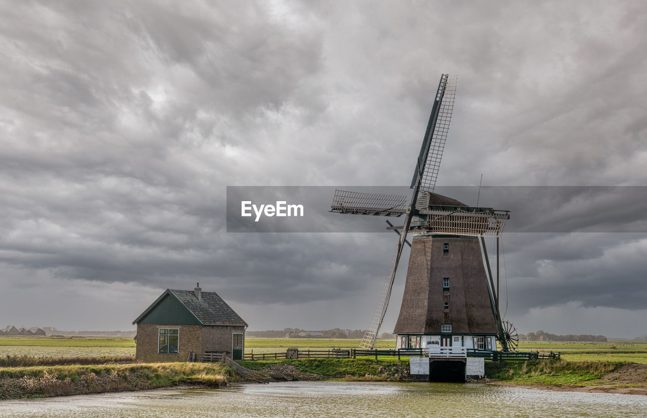 Traditional windmill on field against sky