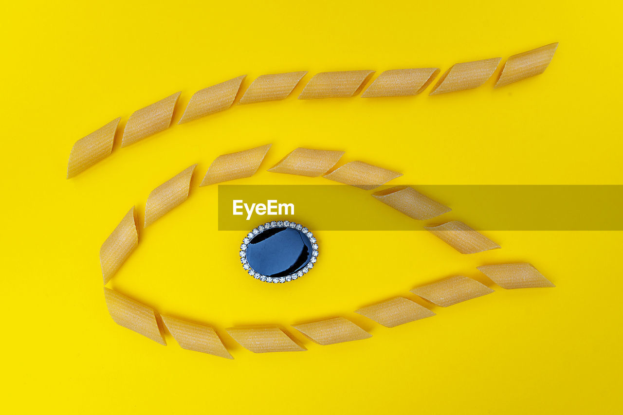 Group of pasta lined up in shape of eye with a jewel in the center. concept of italian tradiction