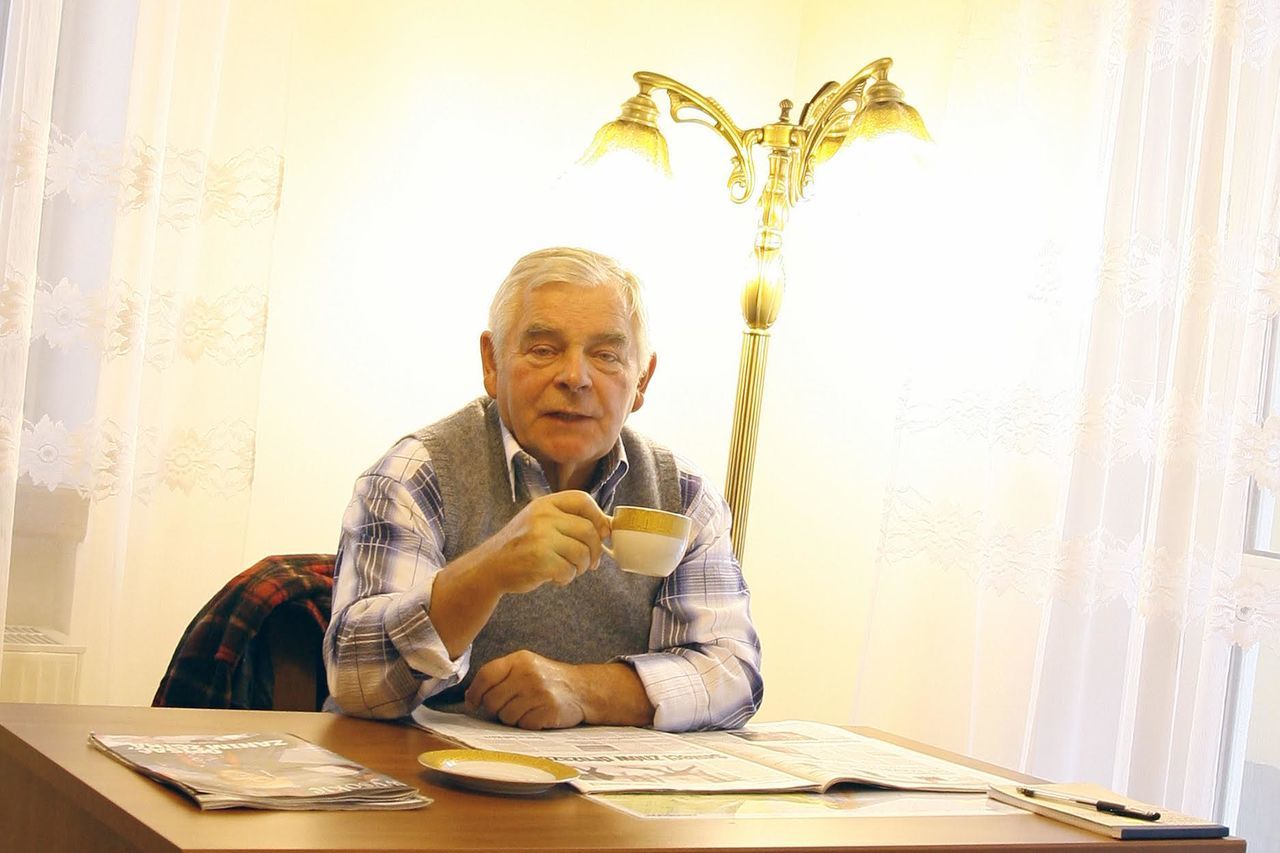 Portrait of senior man drinking coffee at table
