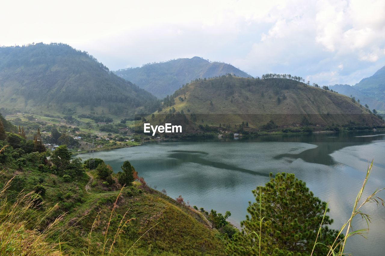 SCENIC VIEW OF BAY AGAINST MOUNTAINS