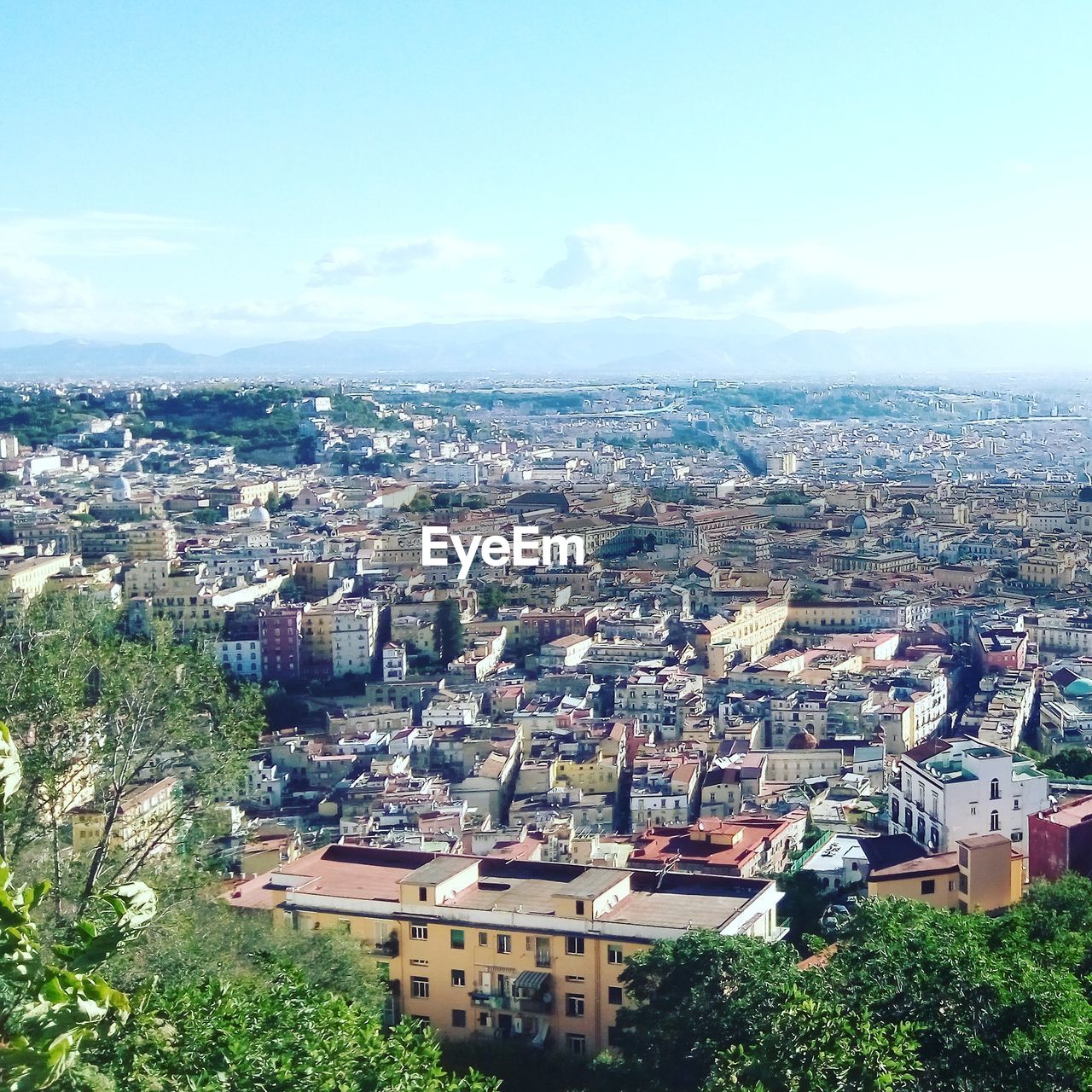 Aerial view of city against cloudy sky