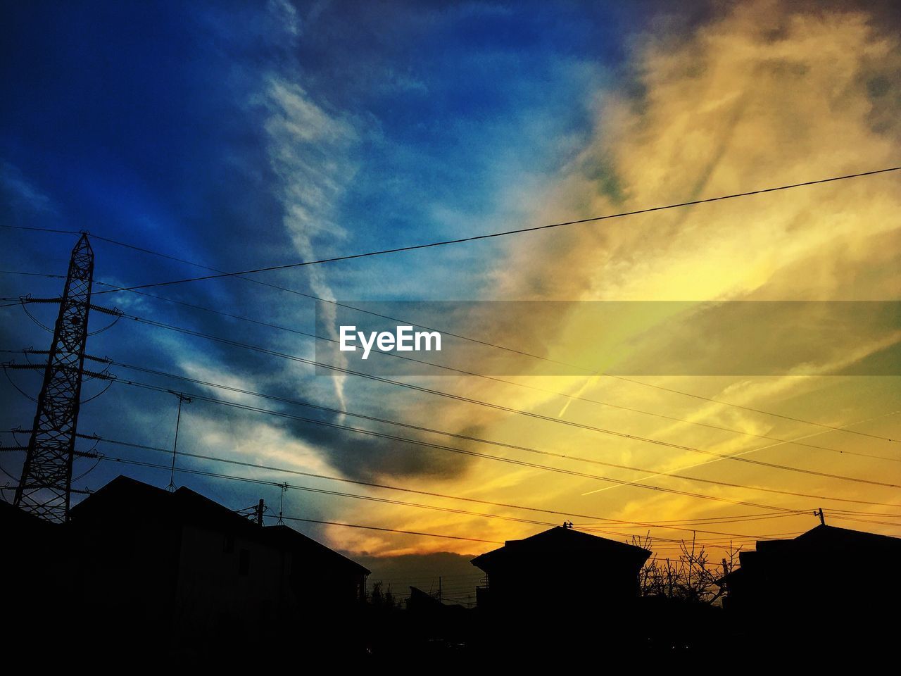 LOW ANGLE VIEW OF ELECTRICITY PYLON AGAINST SKY AT SUNSET