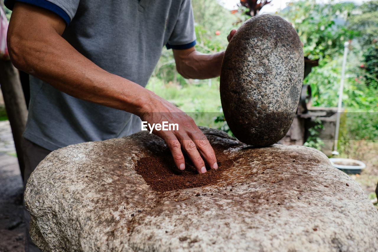 Man grinding coffee with a stone. 