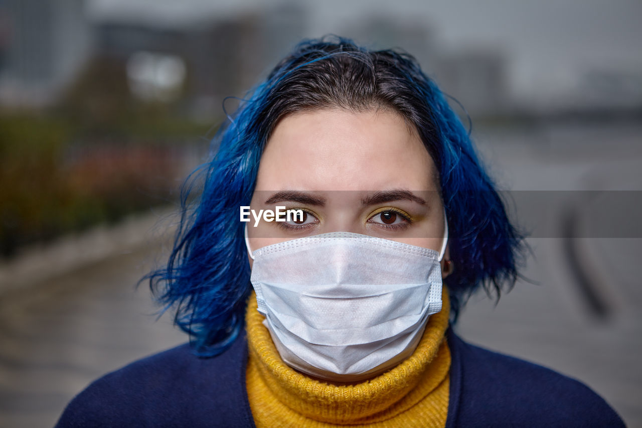 Portrait of woman wearing mask standing outdoors