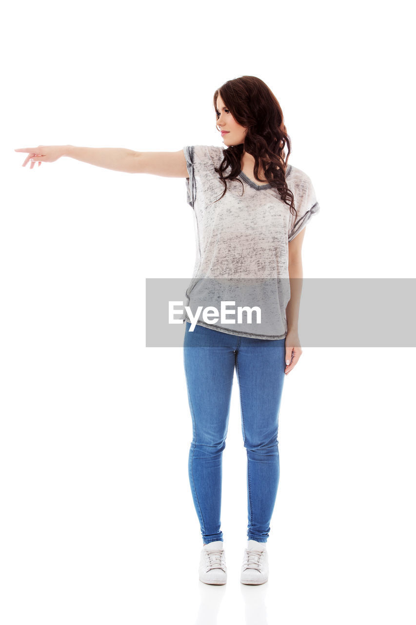 WOMAN STANDING AGAINST WHITE BACKGROUND