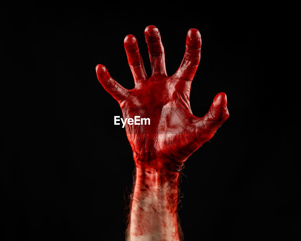 cropped image of human hand against black background