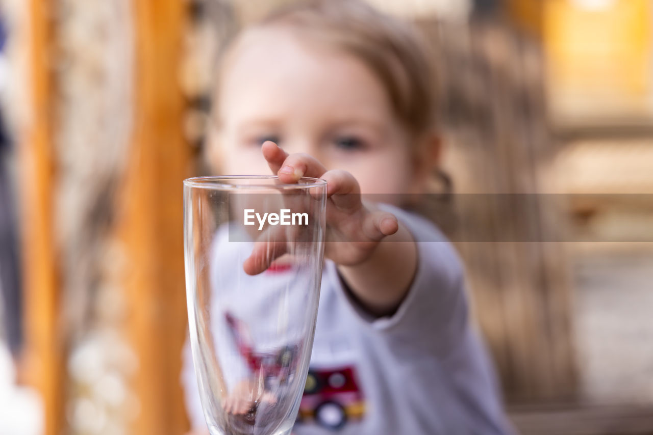 PORTRAIT OF GIRL DRINKING FROM GLASS