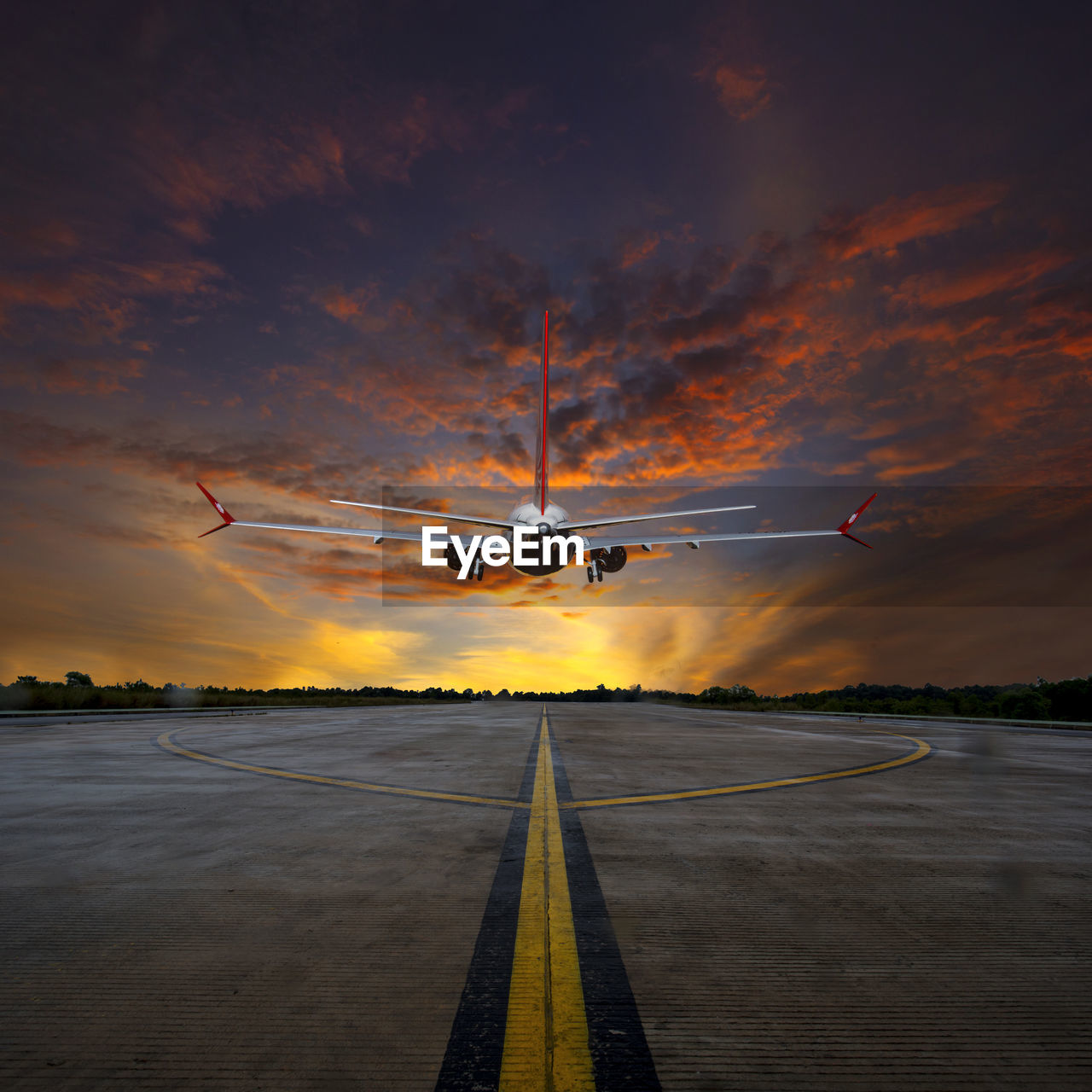 Airplane flying against cloudy sky during sunset