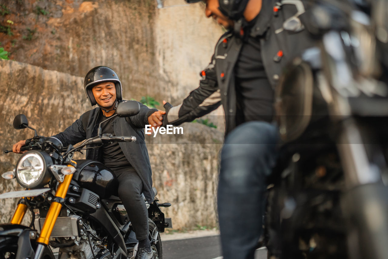 side view of man riding motorcycle on street