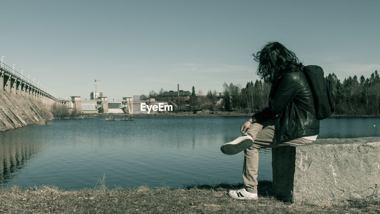 BOY STANDING ON RIVERBANK