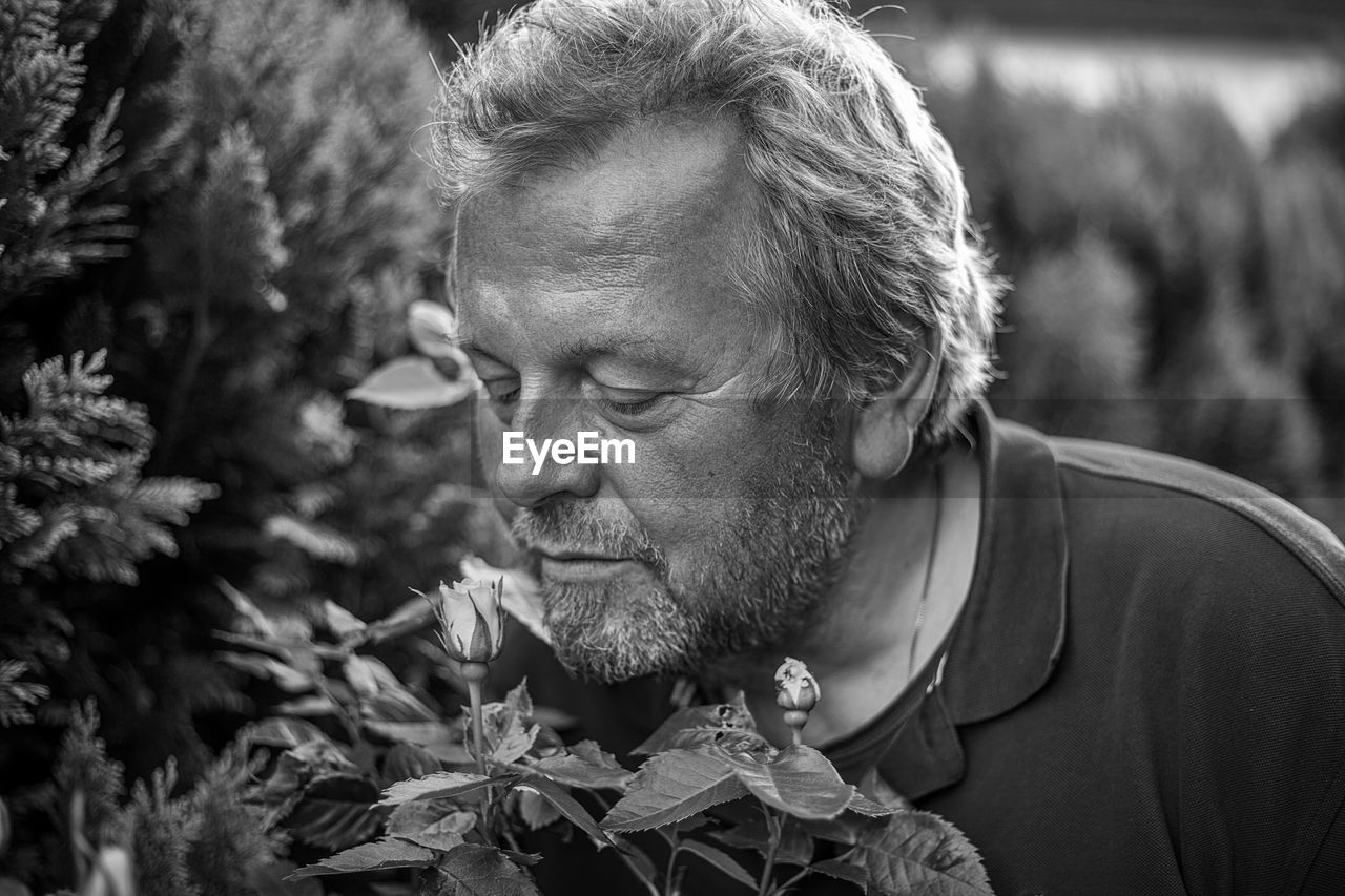 Close-up of man with plants in foreground