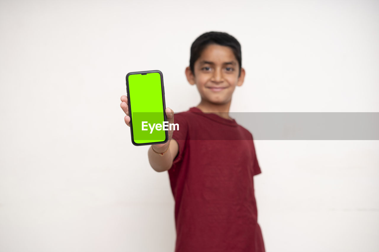PORTRAIT OF SMILING YOUNG MAN HOLDING CAMERA