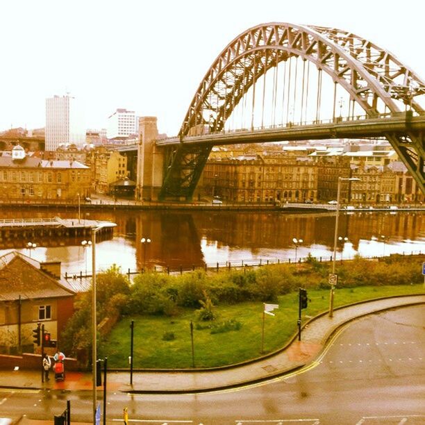 BRIDGE OVER RIVER WITH CITY IN BACKGROUND