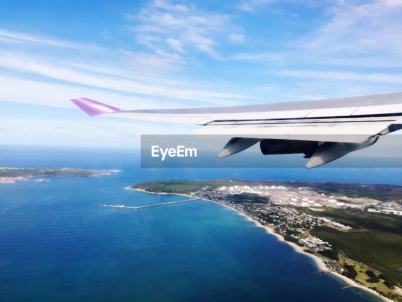 Airplane flying over sea against sky