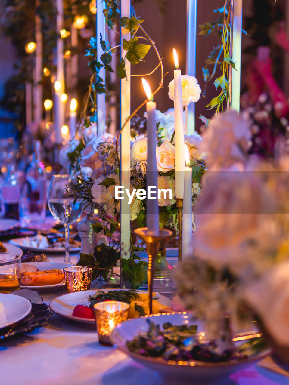 Table served for banquet with candles and floral compositions. beautiful decorations in blue light.