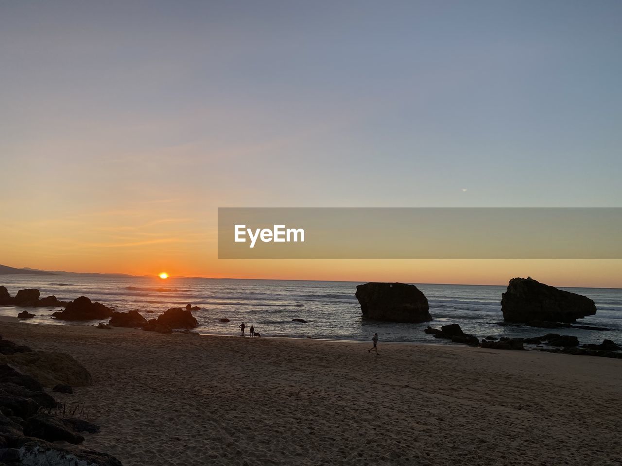 SCENIC VIEW OF BEACH AT SUNSET