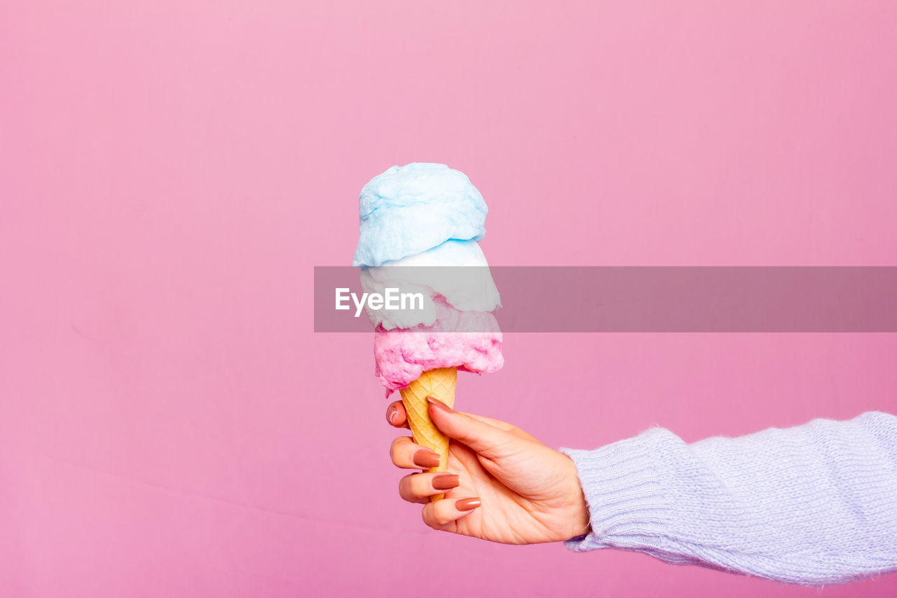 pink, ice cream cone, hand, studio shot, finger, frozen food, colored background, ice cream, indoors, sweet food, sweet, copy space, one person, frozen, cone, dairy, food, food and drink, dessert, pink background, adult, holding, unhealthy eating, arm