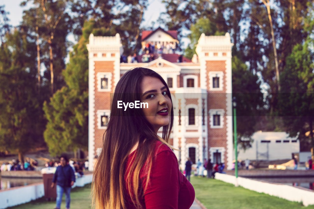 Portrait of smiling woman against building