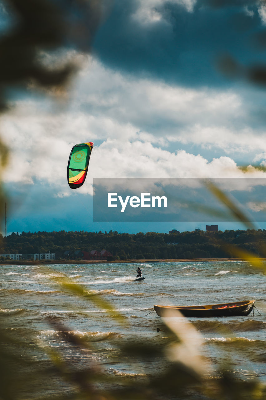 VIEW OF PERSON PARAGLIDING AGAINST SKY