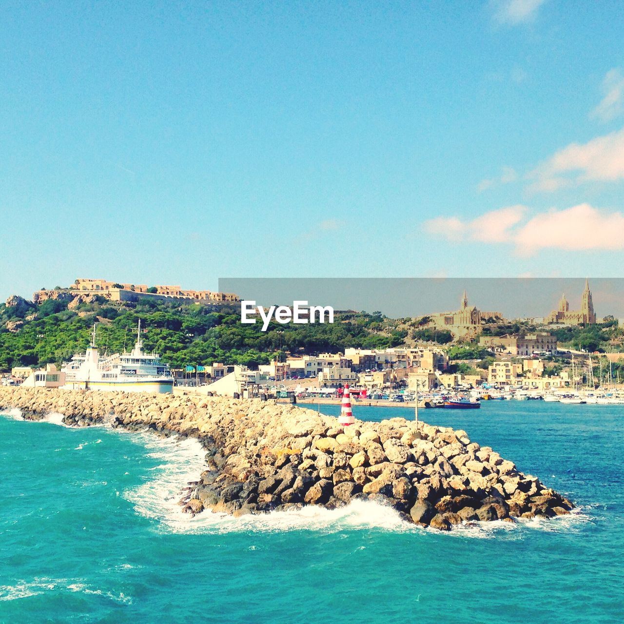 View of town by sea against blue sky