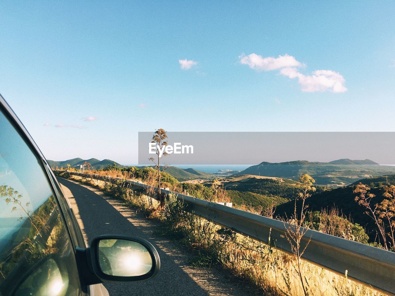 Road by mountains against sky seen through car windshield