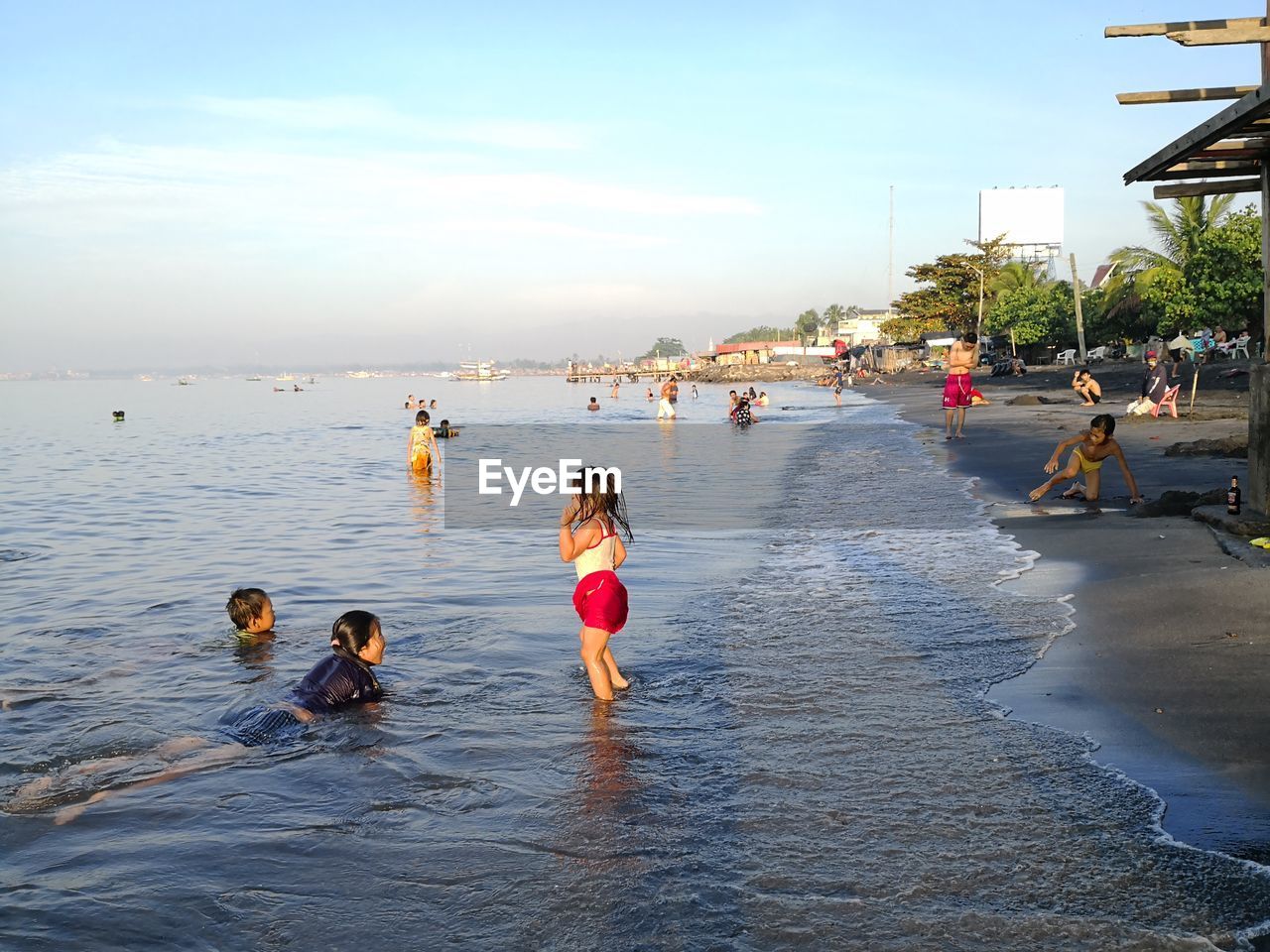 GROUP OF PEOPLE ON SEA SHORE AGAINST SKY