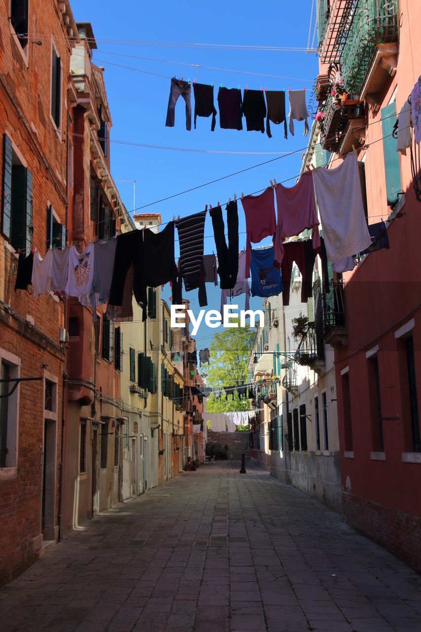 ALLEY AMIDST BUILDINGS AGAINST SKY