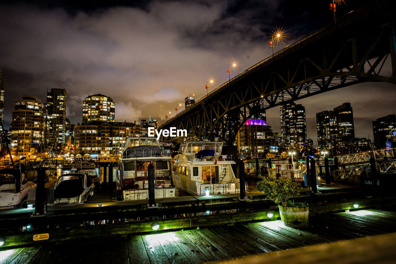 Illuminated cityscape and marina at night