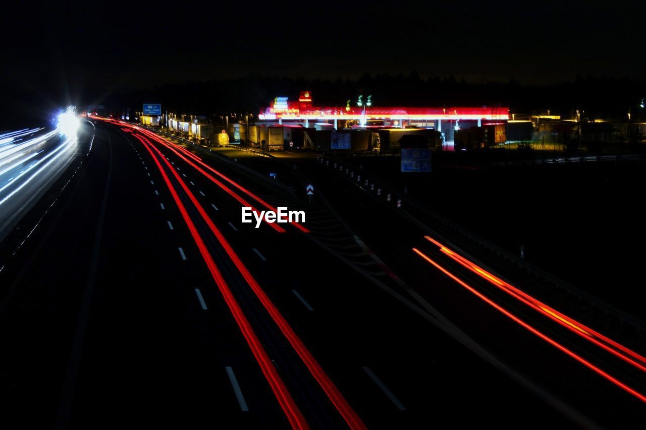 LIGHT TRAILS ON ROAD IN NIGHT