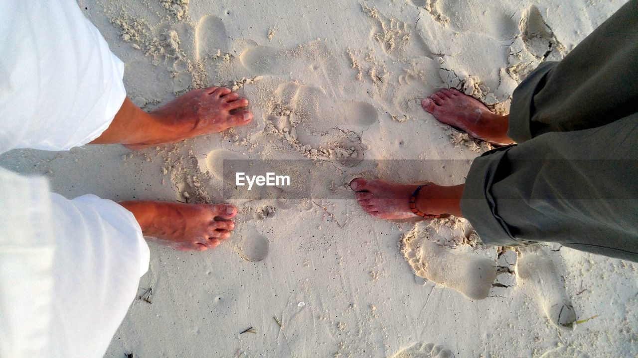 Low section of people standing on beach